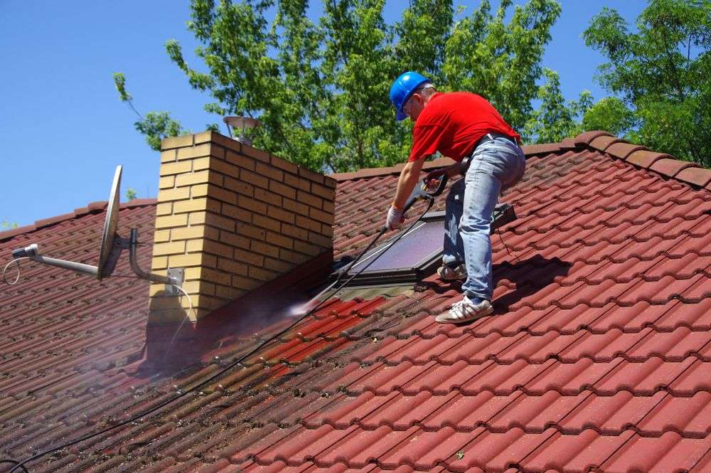 Schoonspuiten van de dakpannen in Rijen